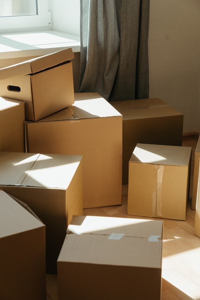 Cardboard boxes in a sunlit room, symbolizing the process of moving into a new home.
